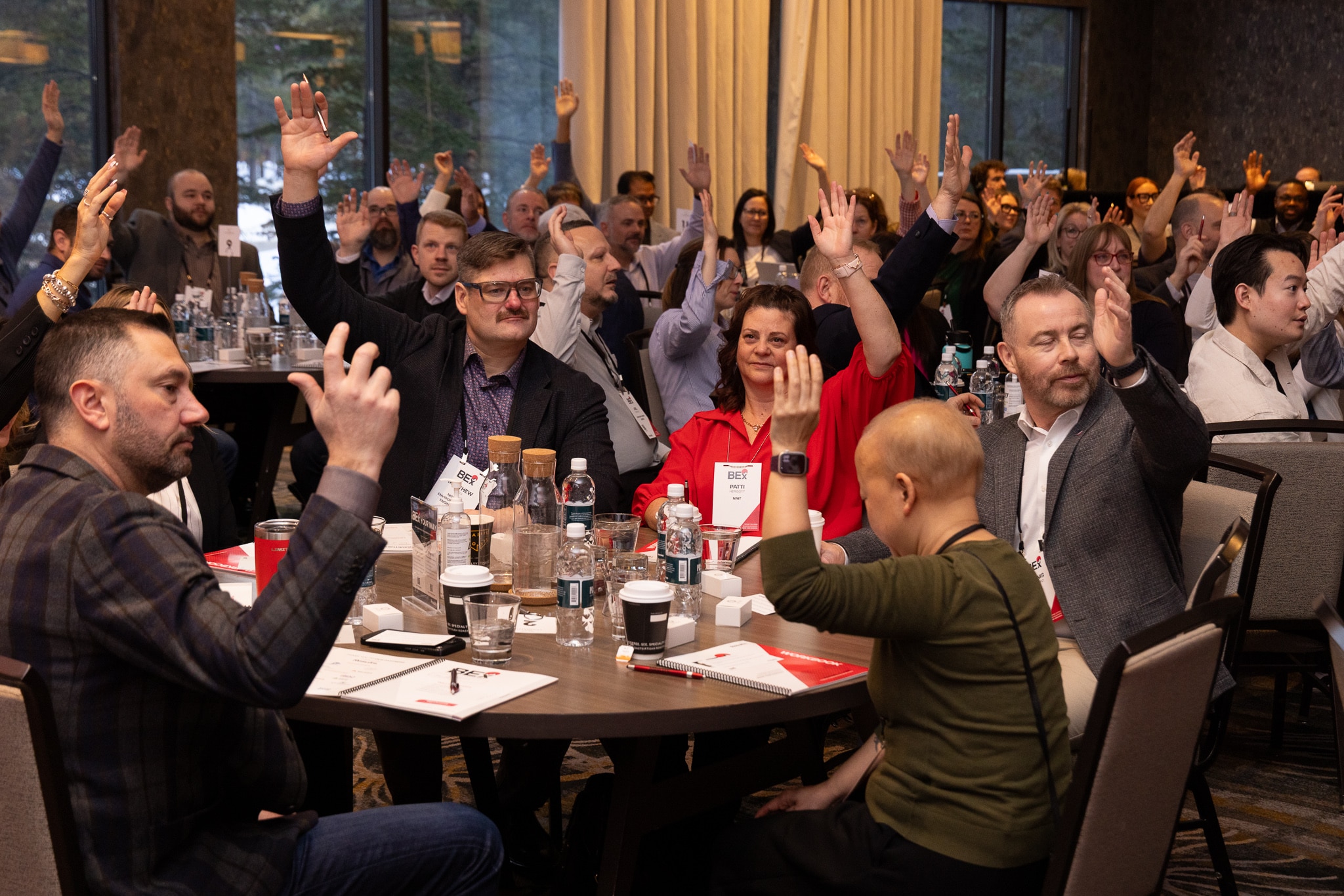 BEx audience with hands raised during interactive keynote session
