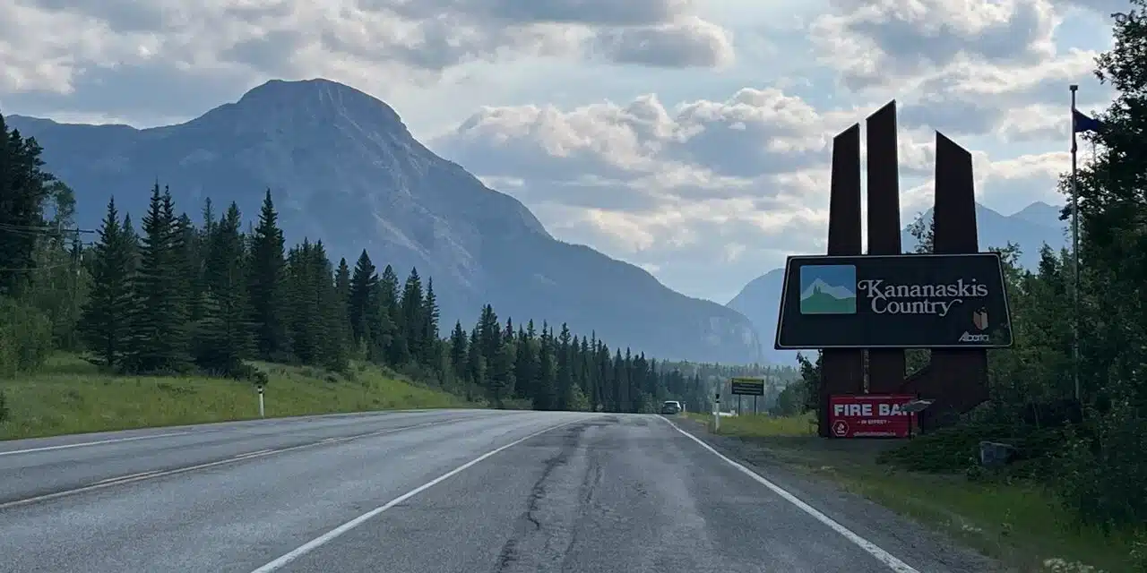 Pomeroy Kananaskis Mountain Lodge sign with snow-capped peak behind